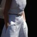 Detail photo of Amy wearing her wedding dress; her face is not showing and her hands are in the pockets. The bottom of her veil is visible.