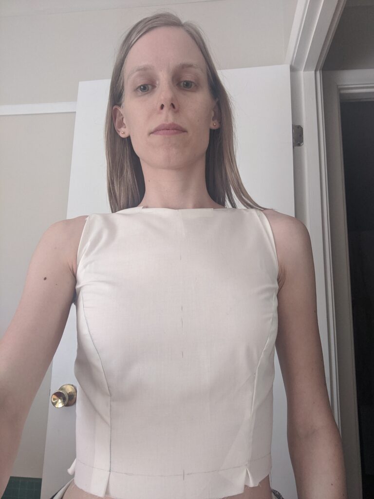 Amy is wearing a mock-up of an early version of her wedding dress bodice pattern. The neckline is very high and the fit is imperfect.