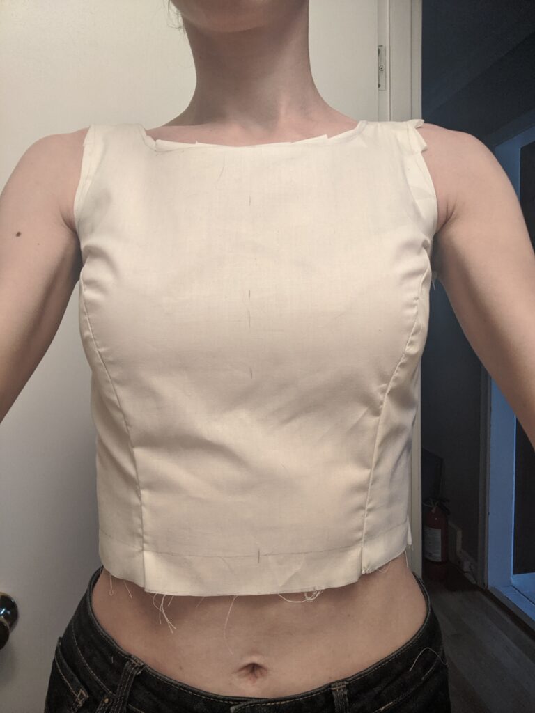 Amy is wearing a mock-up of an early version of her wedding dress bodice pattern. The neckline is just at her collarbones, and the fit is not bad.