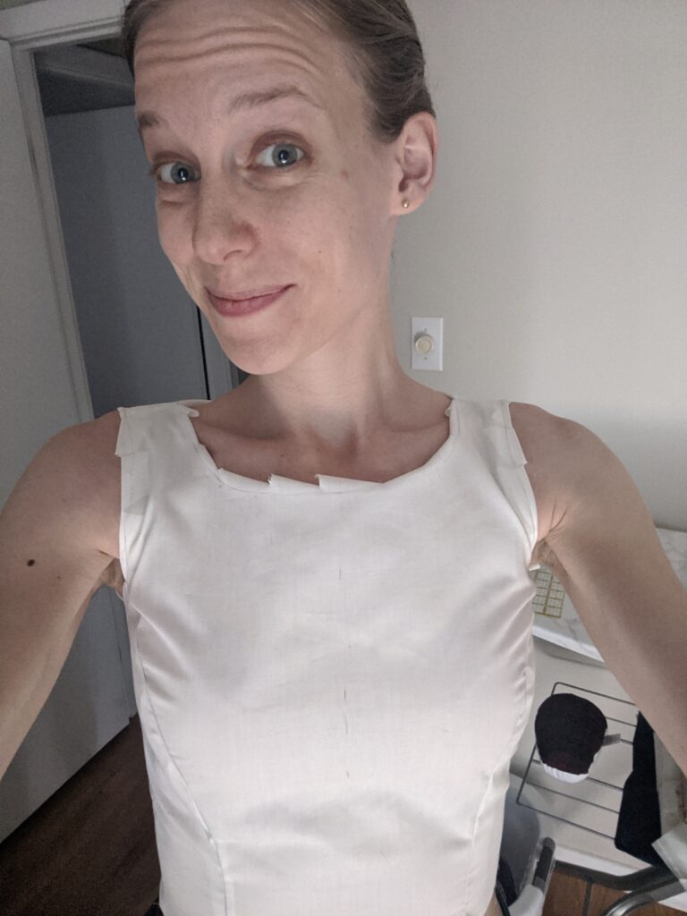 Amy is wearing a mock-up of an early version of her wedding dress bodice pattern. The neckline is just below her collarbones, and the fit is not bad.