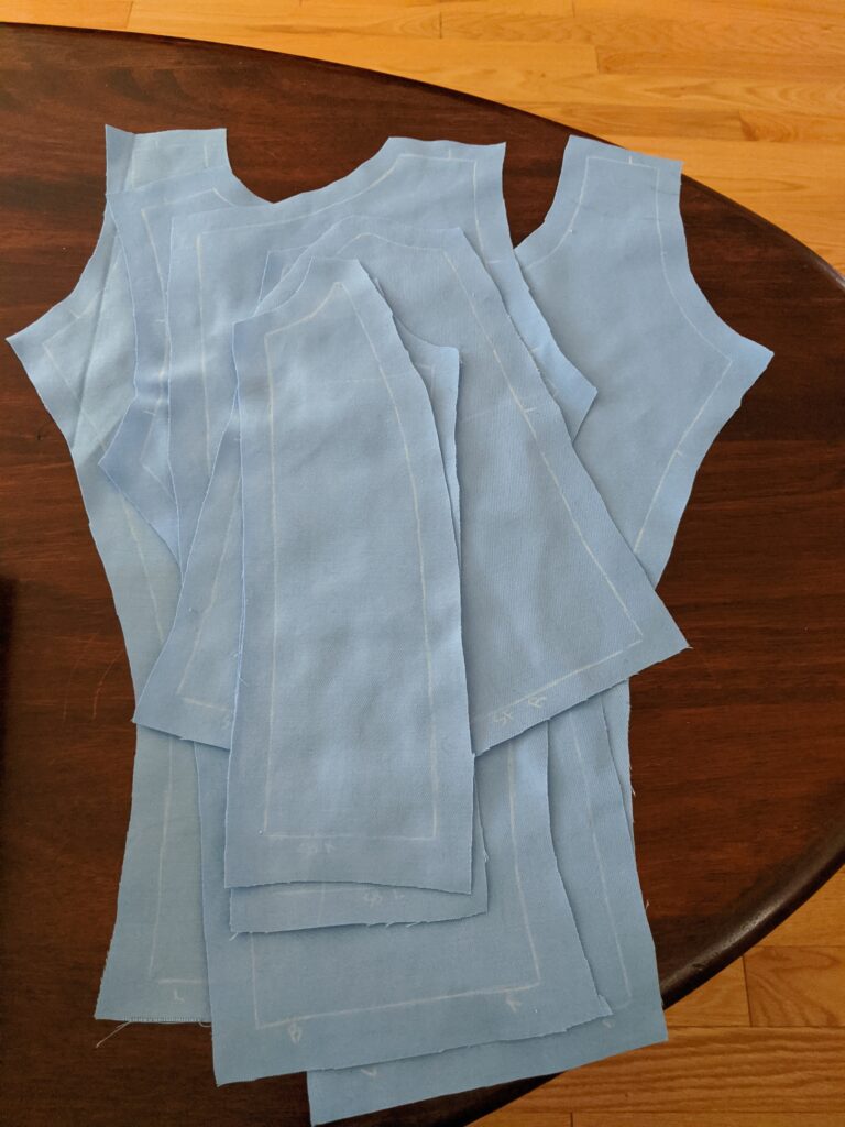 A flat-lay of a partially sewn, blue dress bodice, with princess seams.