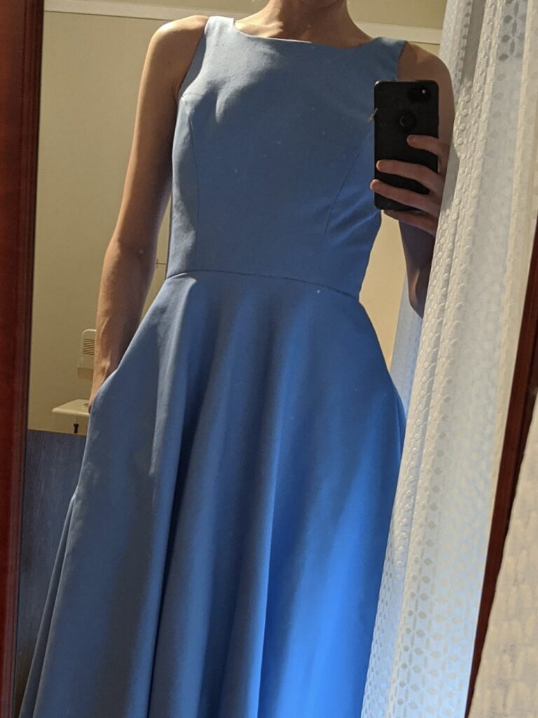A close-up of Amy wearing her blue twill mock-up of her wedding dress. Her head isn't visible, and neither is the bottom of the dress.
