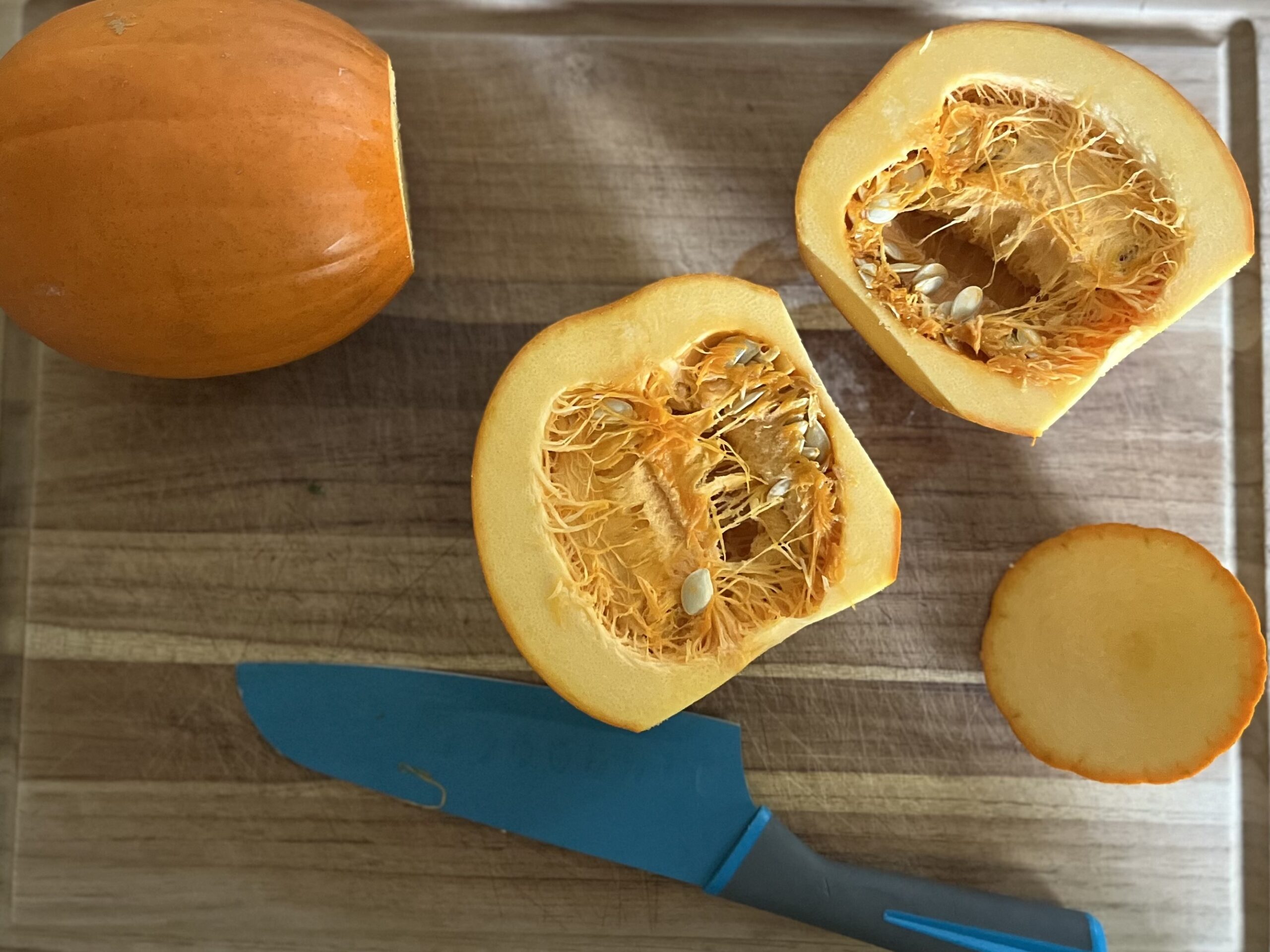 Two pie pumpkins; one is cut open, exposing the flesh and seeds