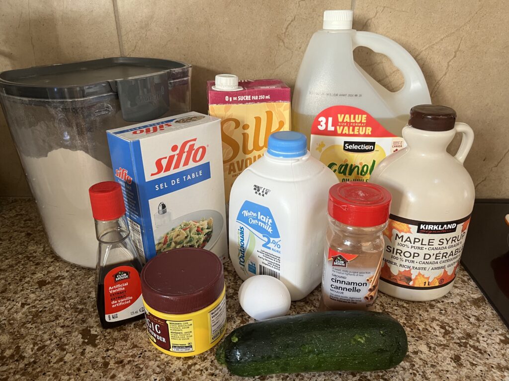 The ingredients for zucchini muffins arranged on a countertop.