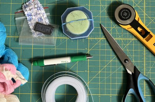 Close-up of a self-healing mat covered with various sewing tools mentioned in this post.