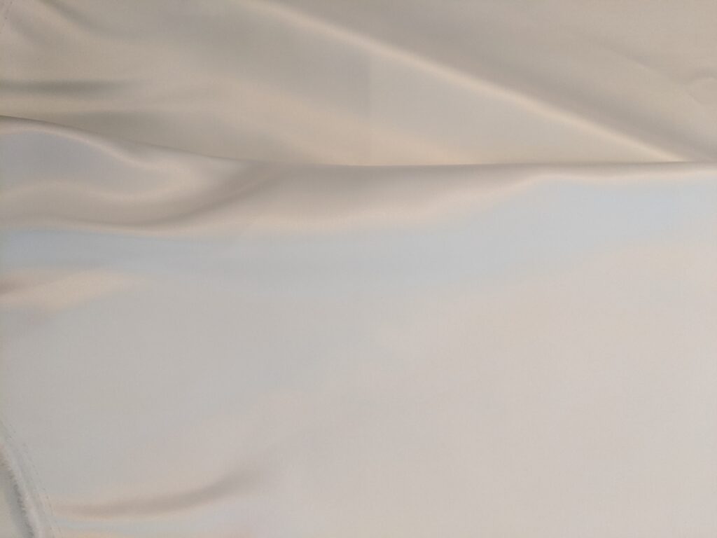 Close-up of the fabric Amy used for her wedding dress. It is white satin