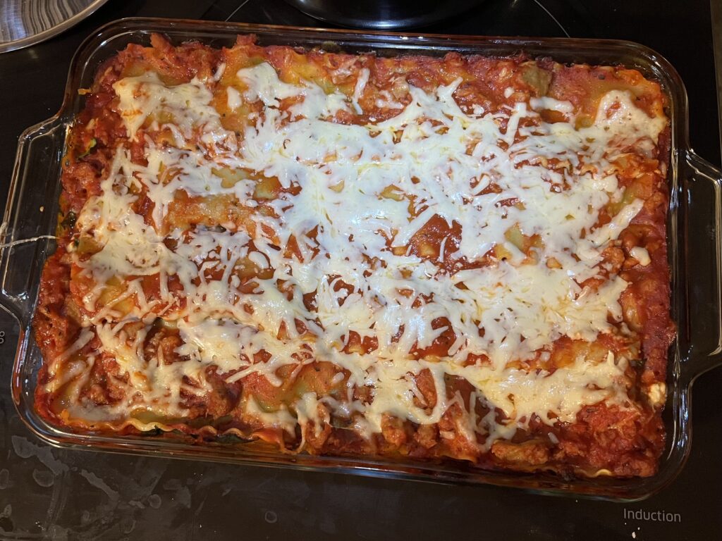 A baked lasagne in a glass pan.