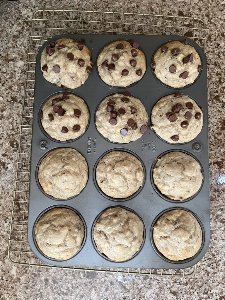 Muffin tin with baked muffins inside. They are lightly browned and rounded.