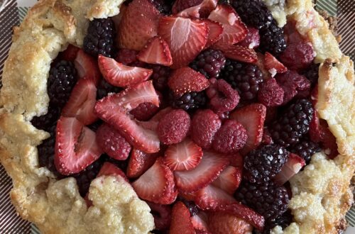 a roughly shaped mixed berry galette (a type of pie), sitting on a serving plate.