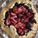 a roughly shaped mixed berry galette (a type of pie), sitting on a serving plate.